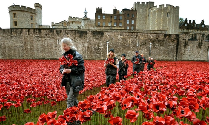 A group of volunteers remove poppies from the moat of the Tower of London, as work begins dismantling the 'Blood Swept Lands and Seas of Red' installation which captured the imagination of Britain as it commemorated the centenary of the First World War
