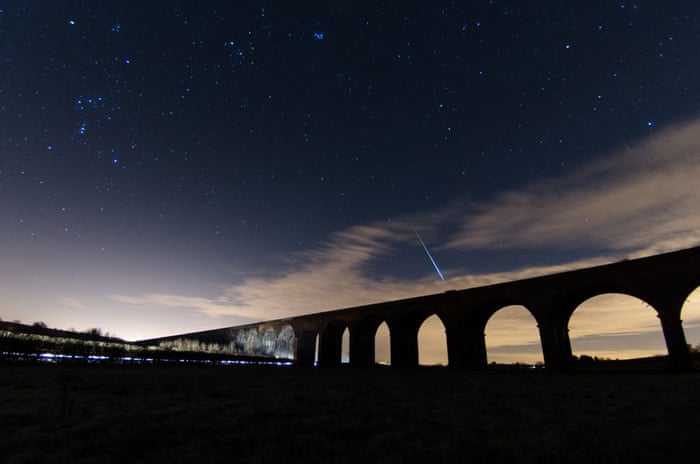 A meteor passes over Harringworth Viaduct in Northamptonshire during the Geminid meteor shower.