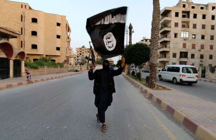 A member of Islamic State waves an Isis flag in Raqqa, Syria on 29 June.