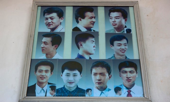 Photos showing example hair styles hang inside a barber shop in Pyongyang in 2013.