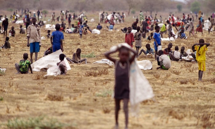 Children flock with containers to a field demarcated for food-drops at a village in Nyal, an administrative hub of Panyijar county in Unity state, south Sudan, on February 24, 2015. Isolated by the Sudd,the world's largest marsh area, population Nyal is protected from the horrors of war that ravaged South Sudan but starved and exposed to disease. Almost all Panyijar County, about 60,000 people dependent on food aid parachuted by the World Food Programme (WFP).