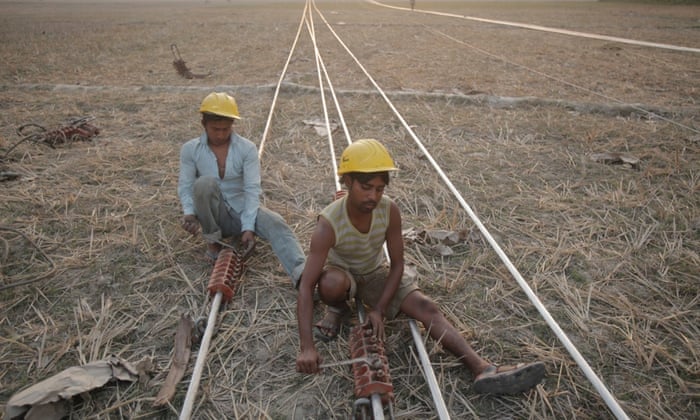 Men work on power transmission lines in Tezpur, India