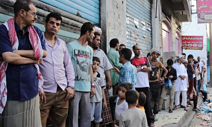 Yemenis wait in line to buy bread 