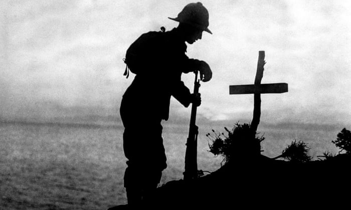 A British soldier pays his respects at the grave of a colleague