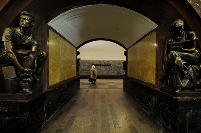 A woman waits on a platform at Ploshchad Revolutsii metro station.