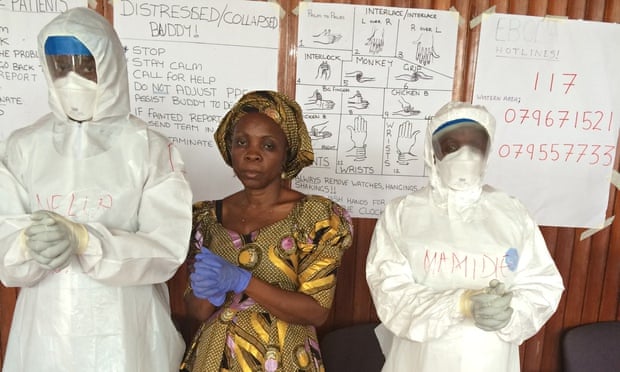 Matron Safula Mansaray instructs the white suit-clad recruits in the 'Ebola pose'