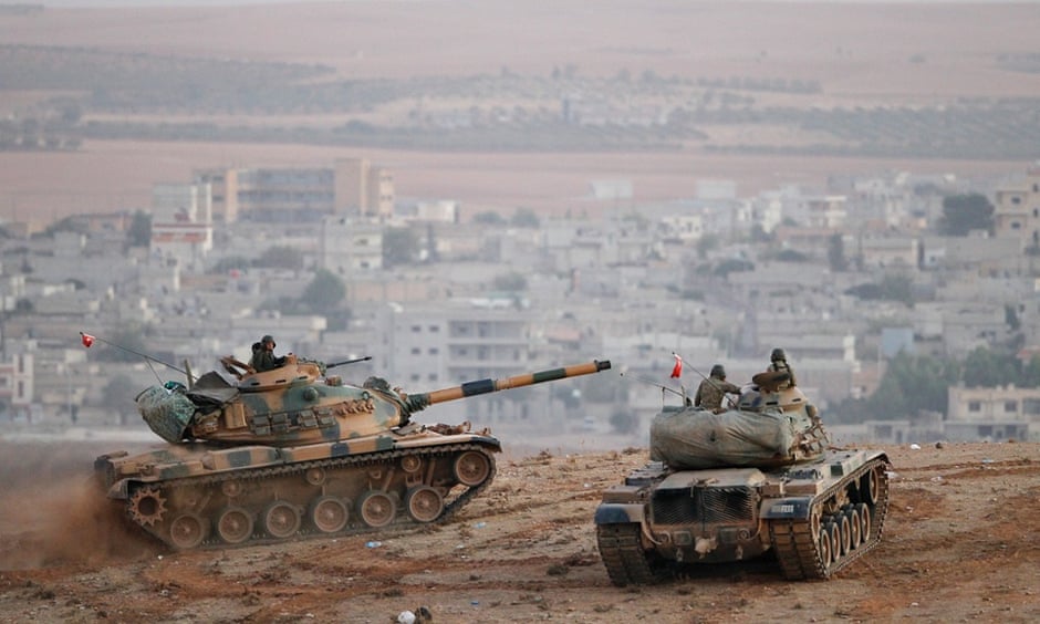 Turkish army tanks keep watch from their side of the border over the Isis-besieged Syrian town of Kobani.