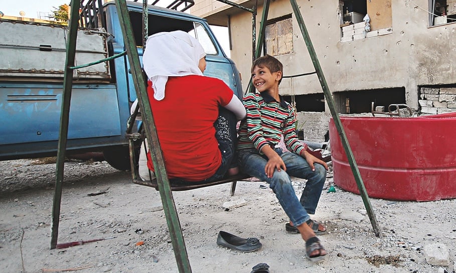 Children play on a swing in Jobar, a suburb of Damascus