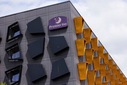 it is a modern, rectangular grey building with protruding black windowframes on one face and yellow on another, giving geometric patterns.