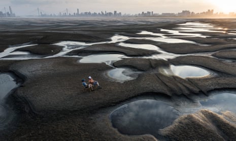 People sitting on a section of a parched river bed along the Yangtze River in Wuhan, China.