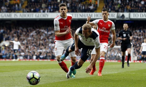Tottenham Hotspur’s Harry Kane, center, goes down after a challenge by Arsenal’s Gabriel and the ref points to the spot.