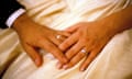a couple hold hands with wedding rings pictured