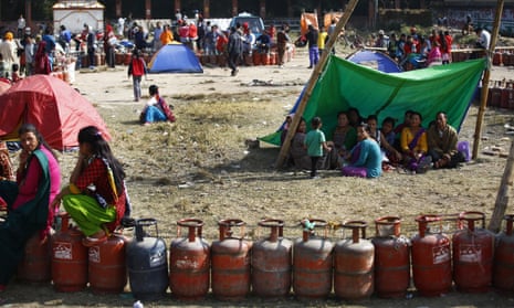 Nepalese citizens sit in temporary shelters as they queue for cooking gas cylinders in Kathmandu