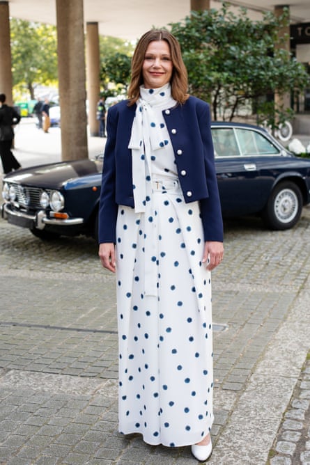 Starmer in a polka-dot high-neck, pussybow jumpsuit. She’s also wearing a cropped blue jacket and white round-toe heels