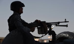 An Afghan policeman keeps watch at a branch office of the National Directorate of Security (NDS) in Kabul after a suicide bomb attack last year.