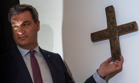 Markus Söder hangs a cross in the entrance area of the Bavarian state chancellery