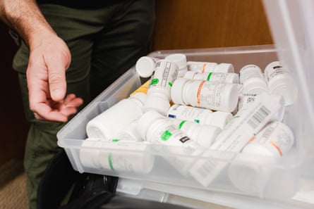 A man inspects a crate full of medication.
