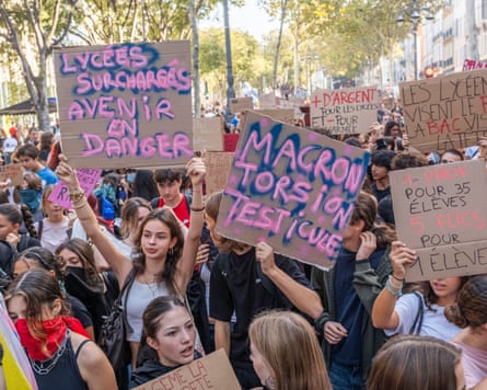 A crowd of students and other protesters holding up placards