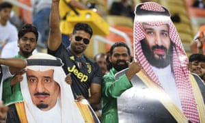 Saudi football fans hold pictures of Prince Mohammed (R) and King Salman
