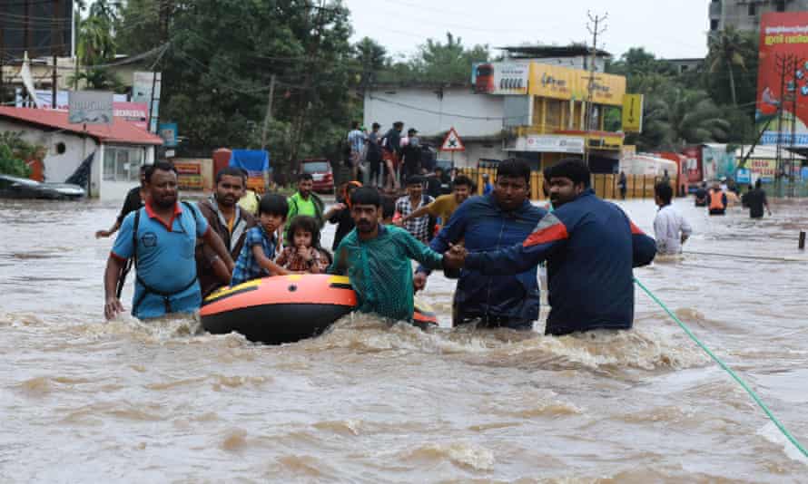 Volunteers and rescue workers evacuate local residents from Ernakulam district