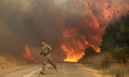 A firefighters runs as wildfire intensifies in Sidiro and Yannuli