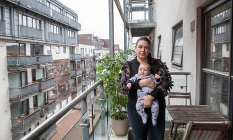 Anastasia Frost and her young baby on the balcony of her apartment in Manchester.