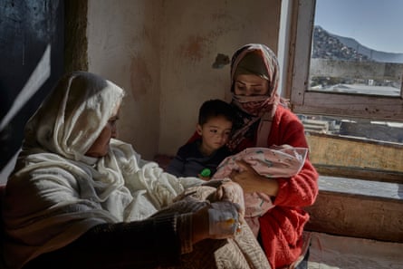 The family of Abdul Sattar* at their accommodation in Kabul: his mother Bibi Khatoon* and his wife Safa*, with two of their children, Ahmad Safa, 2, and a 40-day-old baby son.