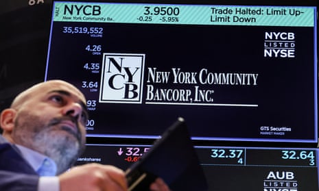 man in front of a screen displaying stock figures for new york community bancorp