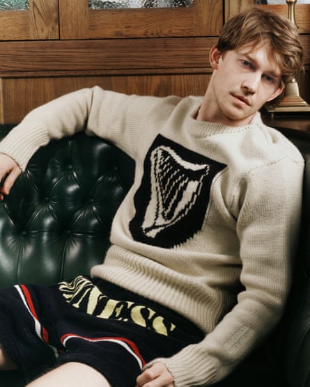 Joe Alwyn wears a unisex ivory coloured Guinness shield harp jumper