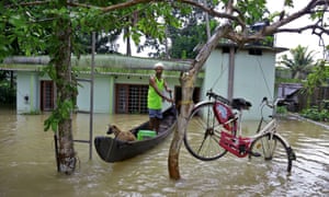 Man on floating boat in front of house