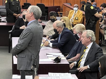 men sit in court as one man stands