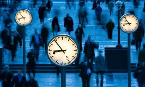 Clocks and people in Canary Wharf, London.