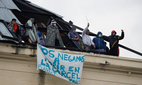 Inmates are seen on the roof of the Devoto prison in Buenos Aires, Argentina, with a banner that reads ‘We refuse to die in jail’ during a riot demanding health measures against coronavirus on 24 April.