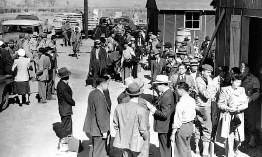 people gather outside small buildings
