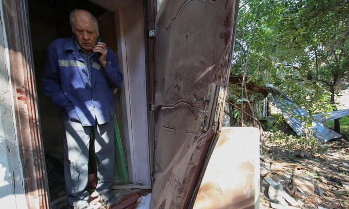 A local resident stands inside an apartment damaged by a Russian military strike in Kharkiv