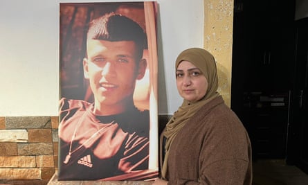 Badriya Hammad holds up a large picture of her son