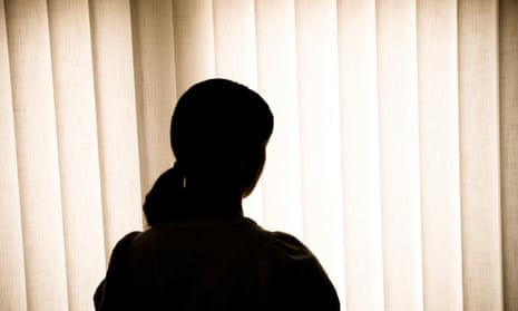 Silhouette of a woman against blinds