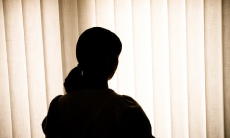 Silhouette of a woman against blinds<br>