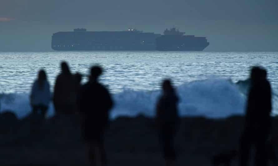 A cargo container ship waits off the coast to enter the Port of Long Beach