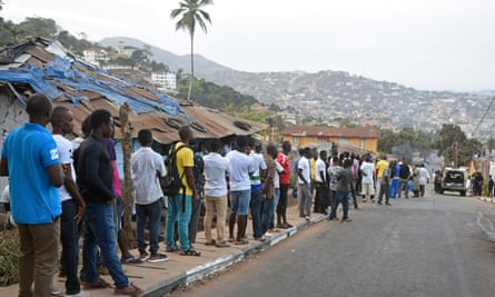 People queue to cast their vote at a polling station during Sierra Leone’s presidential election