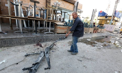 A man drags a piece of debris from the site of the bombing in Baghdad.