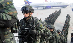 Paramilitary policemen board a plane in Urumqi as they head for an anti-terrorism oath-taking rally in Kashgar.
