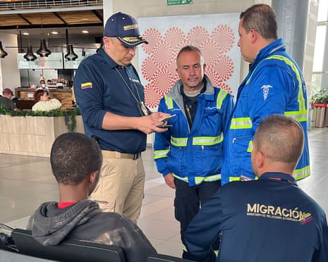 Colombian authorities speak with a young boy at an airport setting.