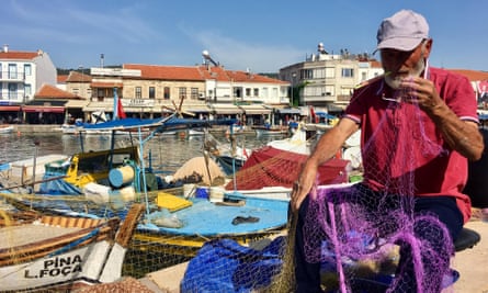 A fisher fixes his nets in Foça harbour.