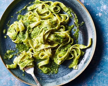 A plate of tagliatelle with watercress and some strands wrapped around a fork
