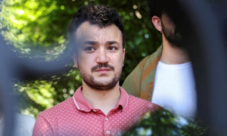 a man in a red top looking at camera