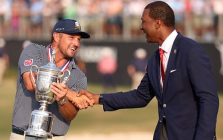Bryson DeChambeau and the USGA’s president, Fred Perpall, pose with the trophy.