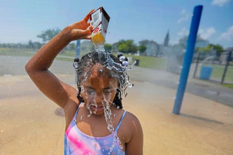 Ja-Veah Cheney, 9, pours water over her head, taking shelter from the sweltering heat at the splash pad station at Riverside Park in New Bedford, Mass.