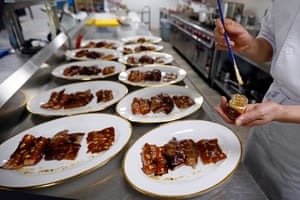 A cook prepares to add edible gold flakes to dishes