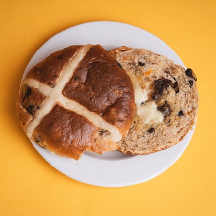 A Tesco Finest brown butter and chai tea hot cross bun, sliced, toasted and buttered, on a white plate